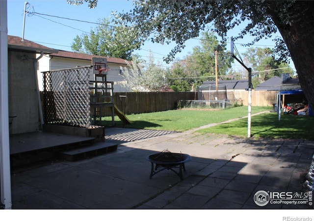 308 Prospect St, Fort Morgan, CO 80701 - fenced backyard with a fire pit, a patio, and a playground