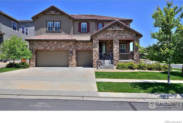 15958 Humboldt Peak Dr, Broomfield, CO 80023 - craftsman-style house with stone siding, board and batten siding, an attached garage, and driveway