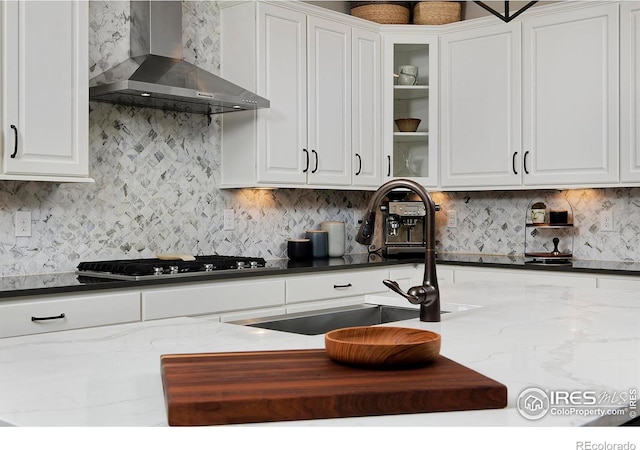 15958 Humboldt Peak Dr, Broomfield, CO 80023 - kitchen with wall chimney exhaust hood, white cabinetry, gas stovetop, and decorative backsplash