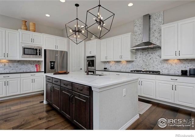 15958 Humboldt Peak Dr, Broomfield, CO 80023 - kitchen with wall chimney range hood, stainless steel appliances, dark wood-type flooring, white cabinets, and recessed lighting