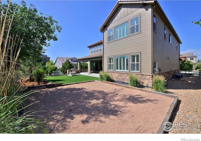 15958 Humboldt Peak Dr, Broomfield, CO 80023 - rear view of house featuring board and batten siding, a patio area, and stone siding