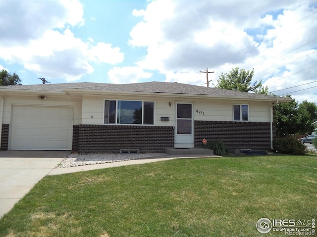 401 31st Ave, Greeley, CO 80634 - view of front of home with brick siding, an attached garage, a front yard, and concrete driveway