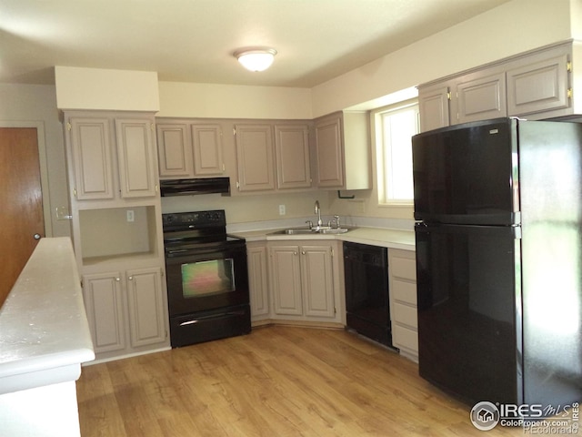 401 31st Ave, Greeley, CO 80634 - kitchen featuring black appliances, under cabinet range hood, light countertops, and light wood-type flooring
