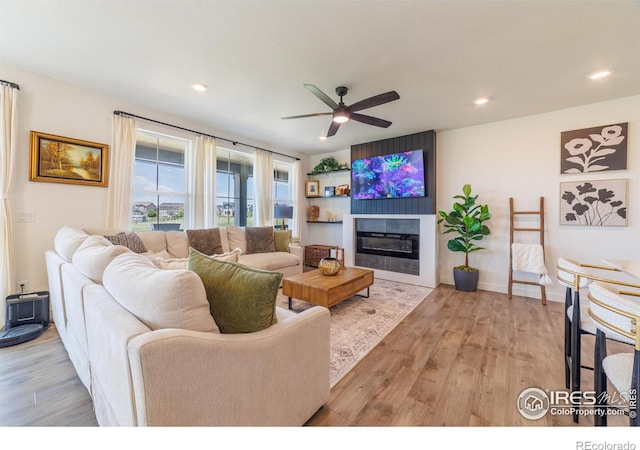 4918 Preserve Pl, Firestone, CO 80504 - living area with a ceiling fan, light wood-style flooring, a glass covered fireplace, and recessed lighting