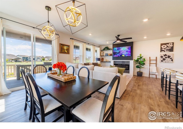 4918 Preserve Pl, Firestone, CO 80504 - dining room with a ceiling fan, light wood-style floors, a glass covered fireplace, recessed lighting, and a chandelier