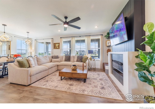 4918 Preserve Pl, Firestone, CO 80504 - living room with wood finished floors, a ceiling fan, a glass covered fireplace, and recessed lighting