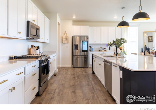 4918 Preserve Pl, Firestone, CO 80504 - kitchen with appliances with stainless steel finishes, light countertops, white cabinets, decorative light fixtures, and recessed lighting