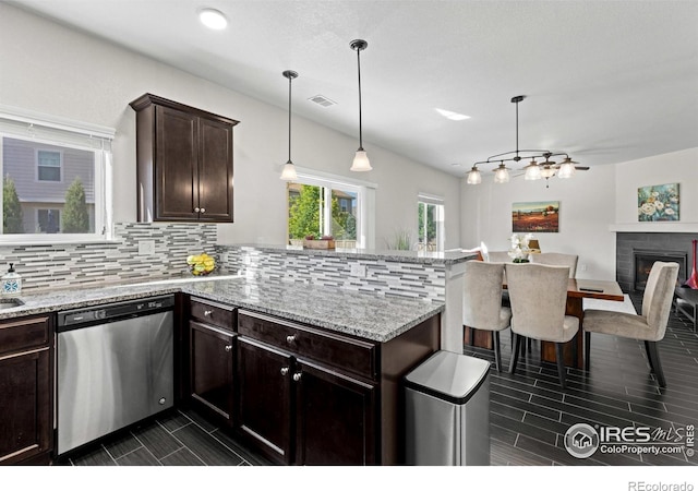 1365 15th Ave, Longmont, CO 80501 - kitchen featuring dishwasher, a peninsula, backsplash, light stone countertops, and dark brown cabinets