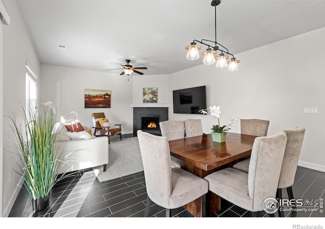 1365 15th Ave, Longmont, CO 80501 - dining area featuring a ceiling fan, wood finish floors, and a lit fireplace