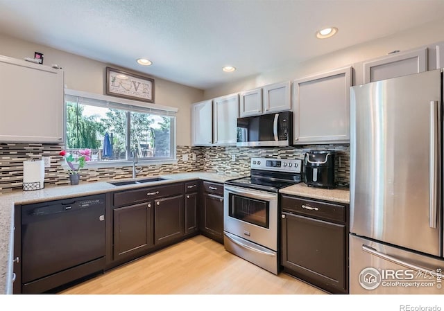 1747 Daisy Ct, Brighton, CO 80601 - kitchen with stainless steel appliances, light wood-style floors, light countertops, decorative backsplash, and recessed lighting