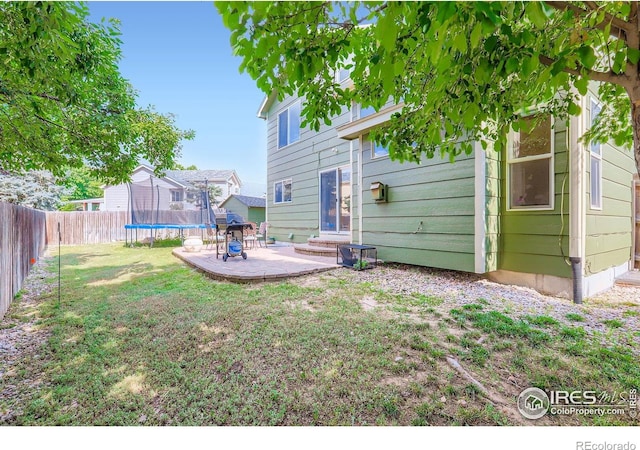 1747 Daisy Ct, Brighton, CO 80601 - fenced backyard featuring a trampoline and a patio