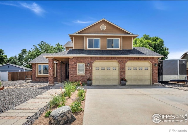 904 Pine Dr, Windsor, CO 80550 - view of front of home with driveway, brick siding, roof with shingles, and an attached garage