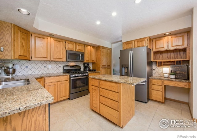 904 Pine Dr, Windsor, CO 80550 - kitchen with stainless steel appliances, decorative backsplash, a center island, light stone counters, and light tile patterned flooring