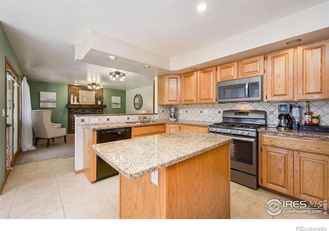 904 Pine Dr, Windsor, CO 80550 - kitchen with appliances with stainless steel finishes, light stone counters, a peninsula, a center island, and light tile patterned floors