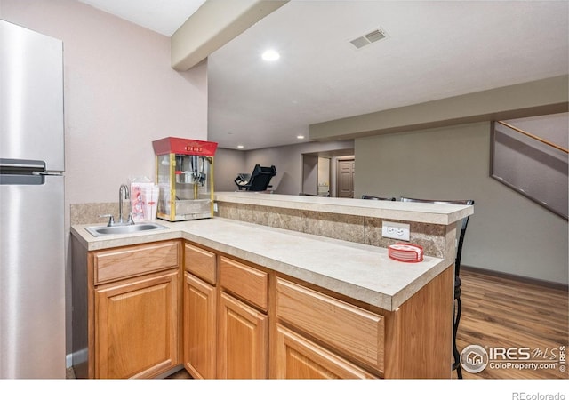 904 Pine Dr, Windsor, CO 80550 - kitchen featuring freestanding refrigerator, a peninsula, light countertops, wood finished floors, and recessed lighting