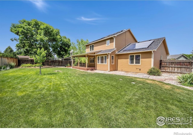 904 Pine Dr, Windsor, CO 80550 - rear view of house with roof mounted solar panels, a fenced backyard, and a patio