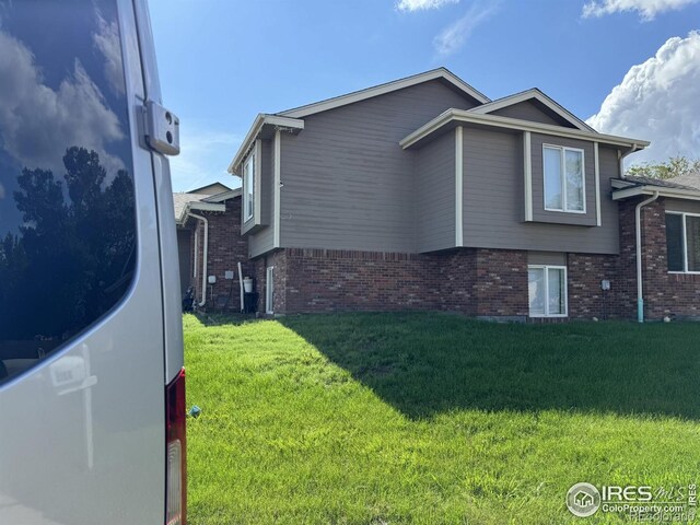 3315 W 35th St, Greeley, CO 80634 - view of side of home featuring brick siding and a yard