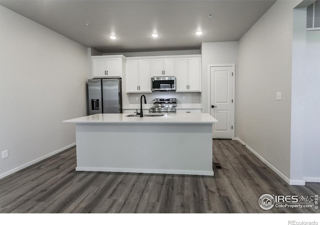 2714 Barnstormer St Unit G, Fort Collins, CO 80524 - kitchen featuring appliances with stainless steel finishes, dark wood-style flooring, a center island with sink, white cabinetry, and light countertops
