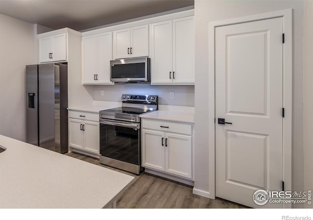 2714 Barnstormer St Unit G, Fort Collins, CO 80524 - kitchen featuring stainless steel appliances, wood finished floors, white cabinetry, and light countertops
