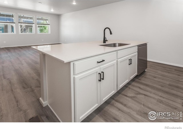2714 Barnstormer St Unit G, Fort Collins, CO 80524 - kitchen featuring stainless steel dishwasher, wood finished floors, white cabinets, a center island with sink, and light countertops