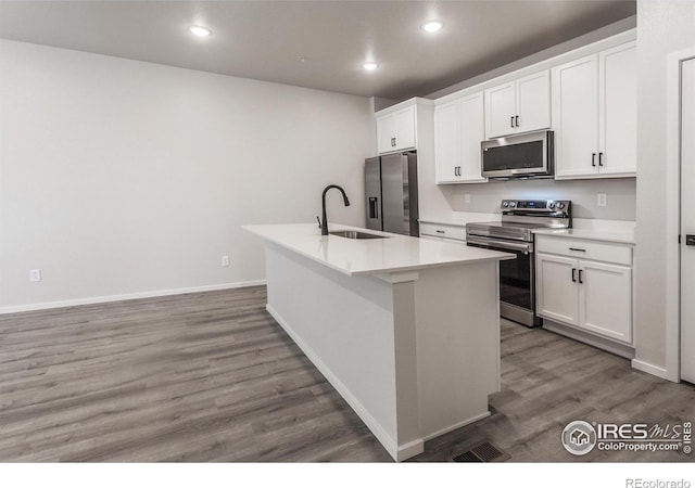 2714 Barnstormer St Unit G, Fort Collins, CO 80524 - kitchen featuring appliances with stainless steel finishes, a center island with sink, light wood finished floors, white cabinetry, and recessed lighting
