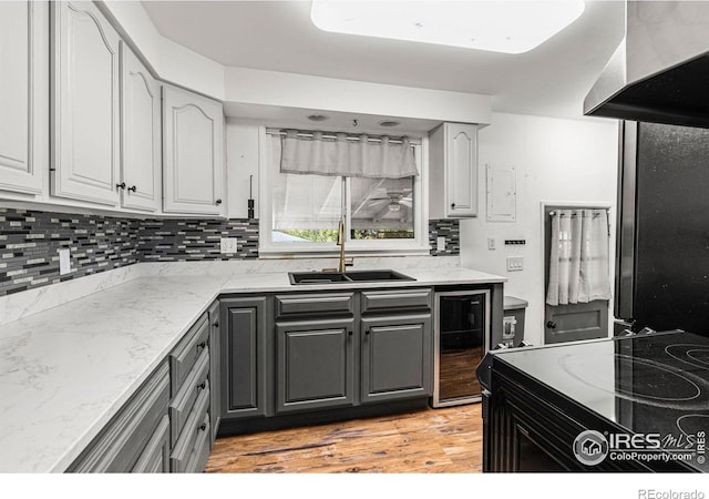 1109 Ironton St, Aurora, CO 80010 - kitchen with range hood, wine cooler, tasteful backsplash, gray cabinets, and light wood-type flooring