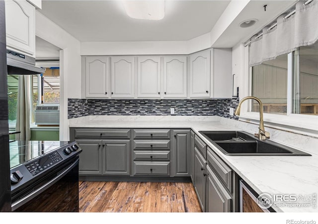 1109 Ironton St, Aurora, CO 80010 - kitchen with gray cabinetry, black electric range oven, ventilation hood, tasteful backsplash, and light stone counters