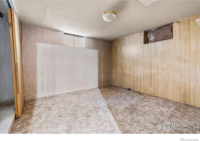 1109 Ironton St, Aurora, CO 80010 - finished basement with wood walls, carpet, and a textured ceiling