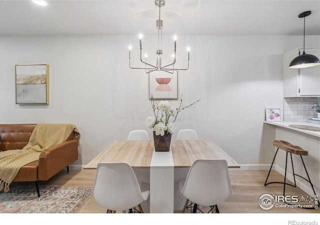 7474 E Arkansas Ave Unit 12, Denver, CO 80231 - dining room featuring a chandelier and light wood finished floors