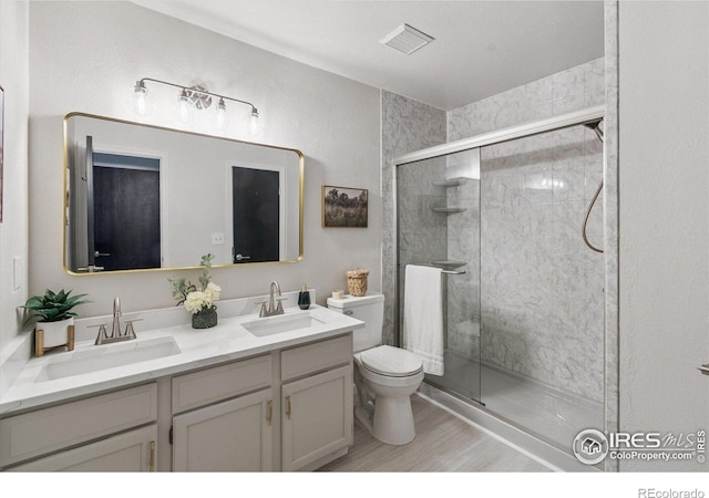 7474 E Arkansas Ave Unit 12, Denver, CO 80231 - full bath with double vanity, a shower stall, and wood finished floors