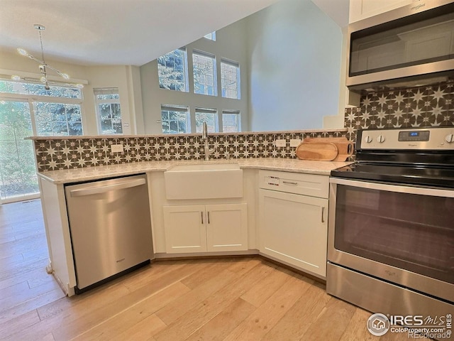 3000 E 112th Ave Unit 102, Northglenn, CO 80233 - kitchen featuring stainless steel appliances, plenty of natural light, and light wood finished floors
