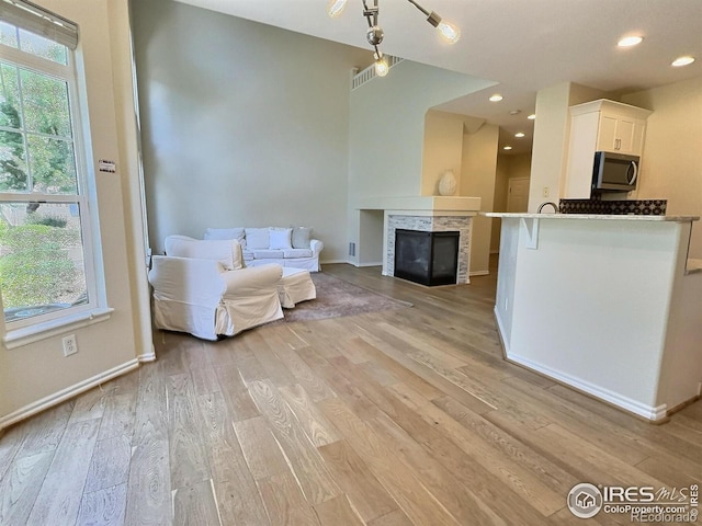 3000 E 112th Ave Unit 102, Northglenn, CO 80233 - living room featuring light wood-style floors, recessed lighting, and a glass covered fireplace