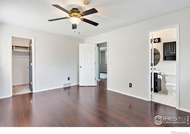 1305 Inverness Dr, Lafayette, CO 80026 - unfurnished bedroom featuring wood finished floors, a walk in closet, a textured ceiling, ceiling fan, and a closet