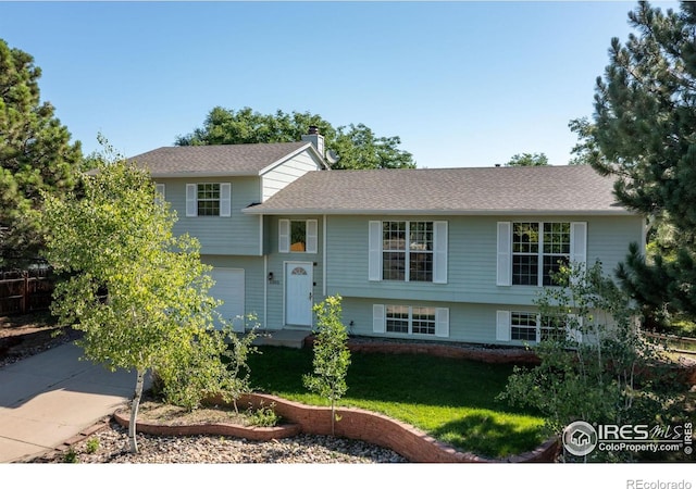 1305 Inverness Dr, Lafayette, CO 80026 - split level home featuring a garage, driveway, a front yard, and a chimney