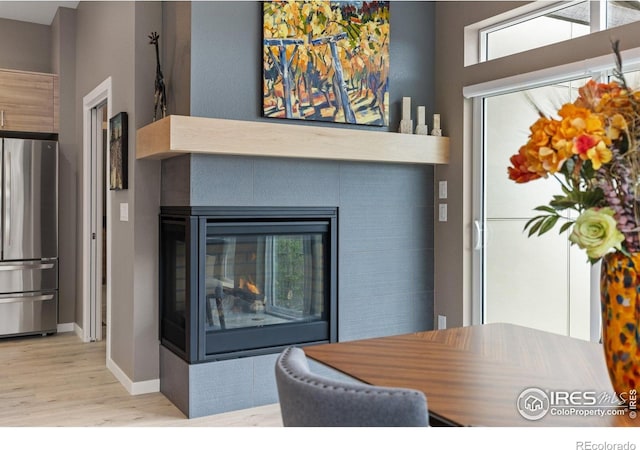 750 Kubat Ln Unit B, Longmont, CO 80503 - detailed view of freestanding refrigerator, wood finished floors, and a multi sided fireplace