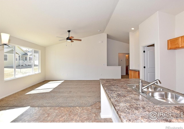 625 87th Ave, Greeley, CO 80634 - kitchen featuring lofted ceiling, ceiling fan, open floor plan, and brown cabinetry