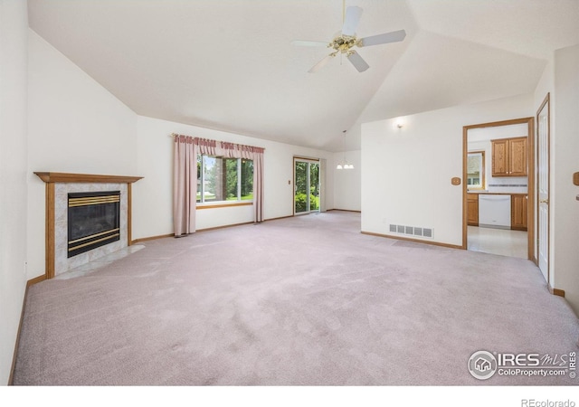 1754 45th Ave, Greeley, CO 80634 - unfurnished living room featuring a ceiling fan, a tile fireplace, light colored carpet, and high vaulted ceiling