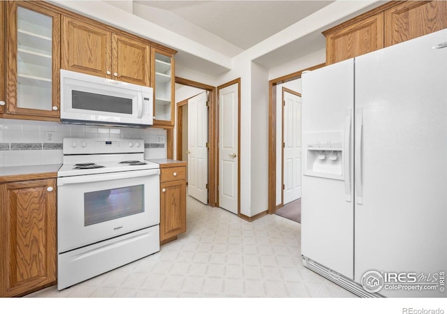 1754 45th Ave, Greeley, CO 80634 - kitchen featuring white appliances, light floors, brown cabinets, and light countertops