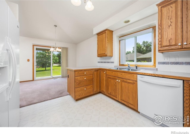 1754 45th Ave, Greeley, CO 80634 - kitchen with white appliances, a chandelier, vaulted ceiling, plenty of natural light, and brown cabinets