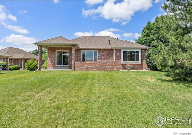 1754 45th Ave, Greeley, CO 80634 - back of house featuring brick siding, a lawn, and a shingled roof