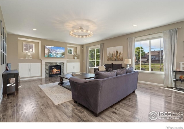 8541 Allenbrook Dr, Windsor, CO 80550 - living room with wood finished floors, a stone fireplace, and recessed lighting