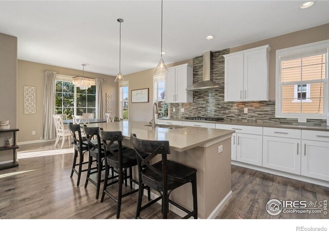 8541 Allenbrook Dr, Windsor, CO 80550 - kitchen featuring wall chimney exhaust hood, dark wood-style flooring, stainless steel gas cooktop, decorative backsplash, and recessed lighting