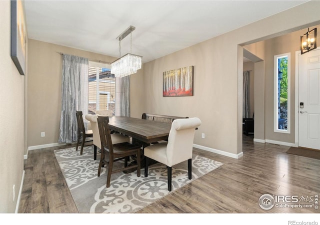 8541 Allenbrook Dr, Windsor, CO 80550 - dining room featuring a chandelier, wood finished floors, and plenty of natural light