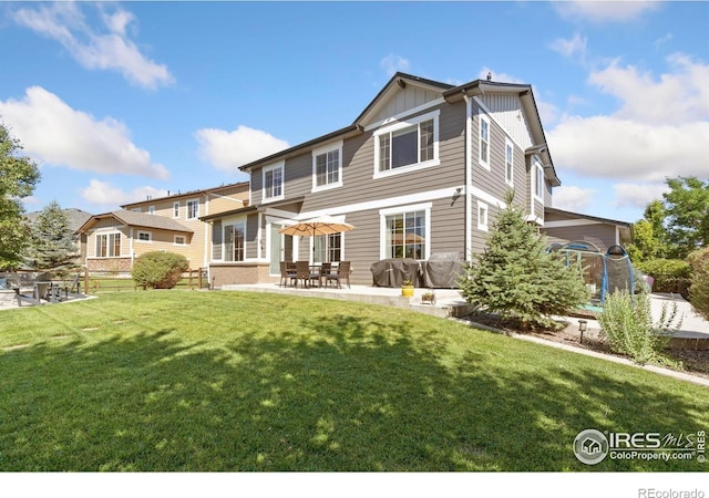 8541 Allenbrook Dr, Windsor, CO 80550 - rear view of property with board and batten siding, a patio area, and a lawn