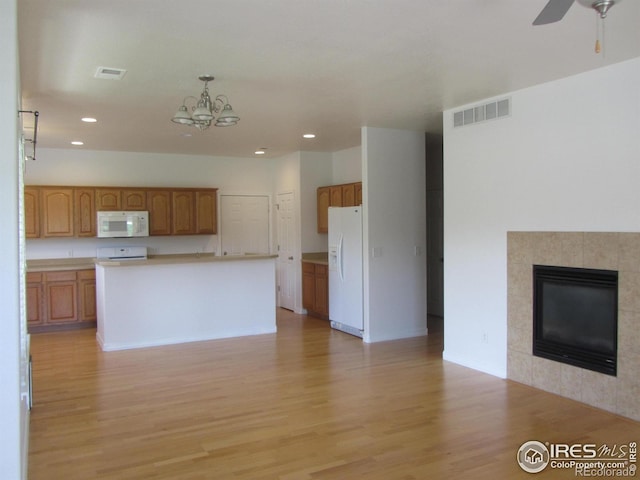1900 68th Ave Unit 701, Greeley, CO 80634 - kitchen with white appliances, open floor plan, light wood finished floors, recessed lighting, and brown cabinetry