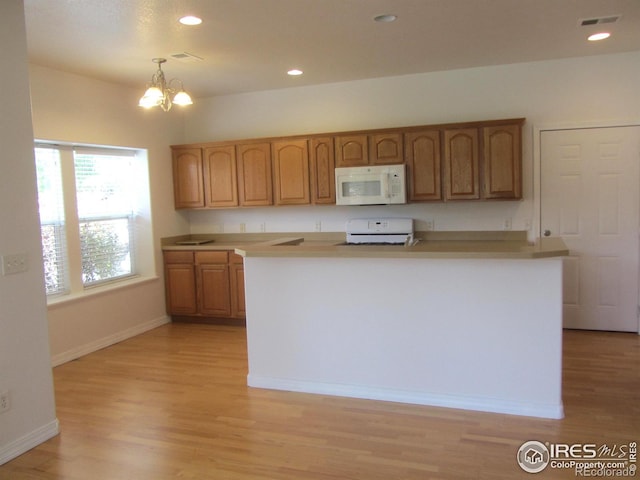 1900 68th Ave Unit 701, Greeley, CO 80634 - kitchen featuring white microwave, stove, light wood-style flooring, and recessed lighting