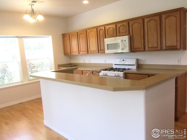 1900 68th Ave Unit 701, Greeley, CO 80634 - kitchen featuring white appliances, healthy amount of natural light, brown cabinetry, and recessed lighting