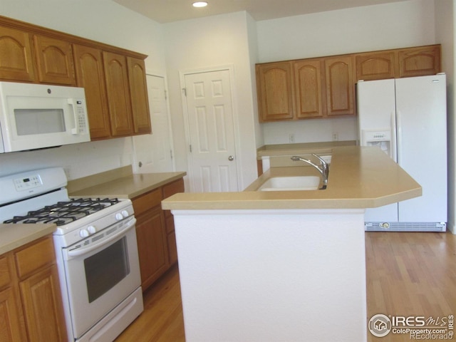 1900 68th Ave Unit 701, Greeley, CO 80634 - kitchen featuring white appliances, a kitchen island with sink, light wood-style floors, light countertops, and recessed lighting