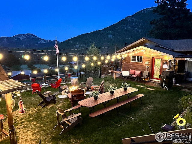 2238 Eagle Cliff Rd, Estes Park, CO 80517 - back of house at twilight with a mountain view, an outdoor fire pit, and a yard