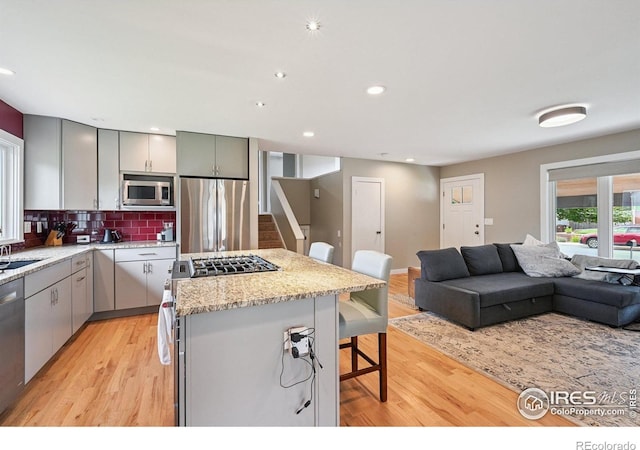 4655 Macky Way, Boulder, CO 80305 - kitchen with stainless steel appliances, gray cabinets, a breakfast bar area, open floor plan, and a kitchen island